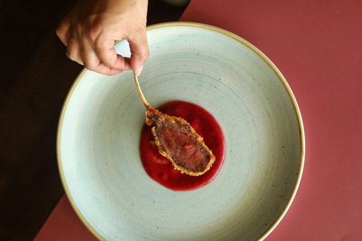 hand holding the end of a bone on a piece of meat