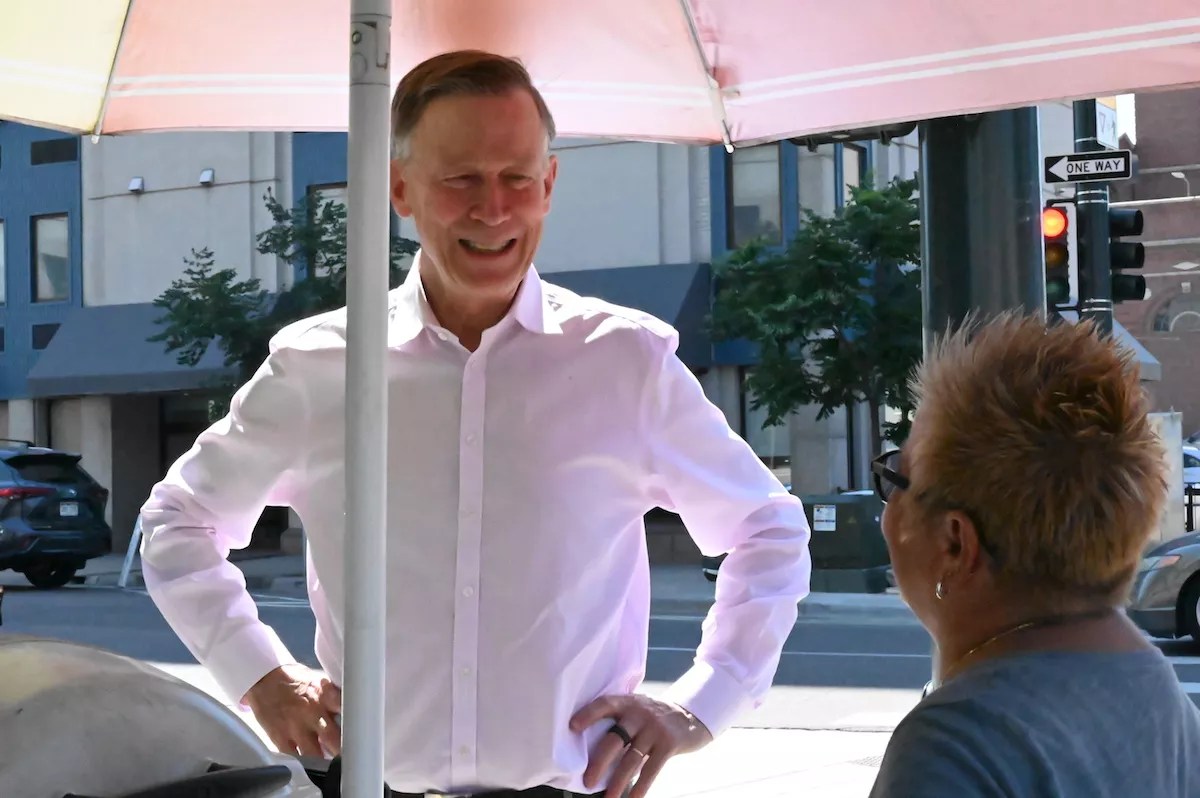 John Hickenlooper talks with Marcella Armas at her hot dog cart on 14th Avenue and Cherokee Street.