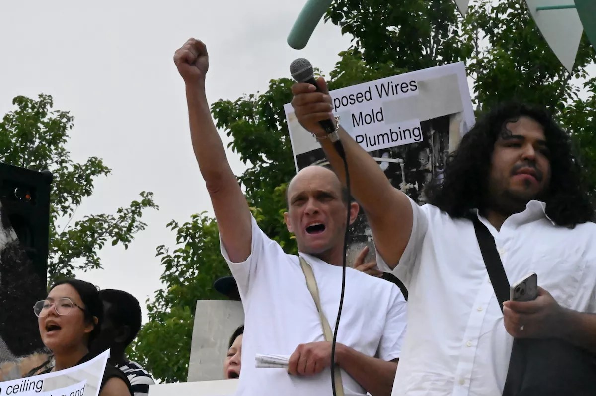 Michael Lunsford holds up his fit alongside other protesters at a rally at Fletcher Plaza in Aurora.