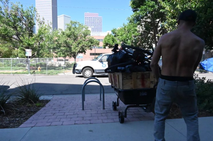 A homeless resident moves their things during a sweep.