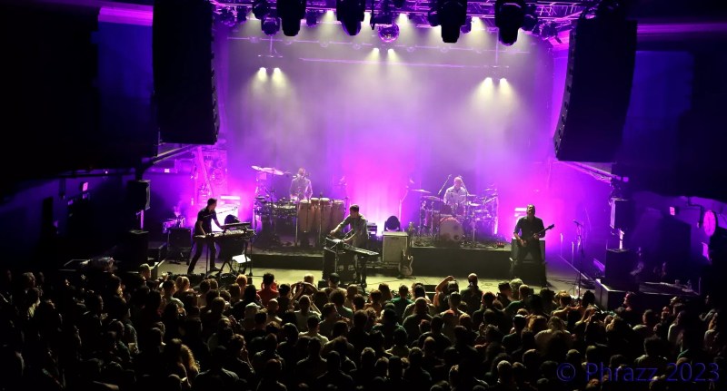 band playing on stage with purple lights