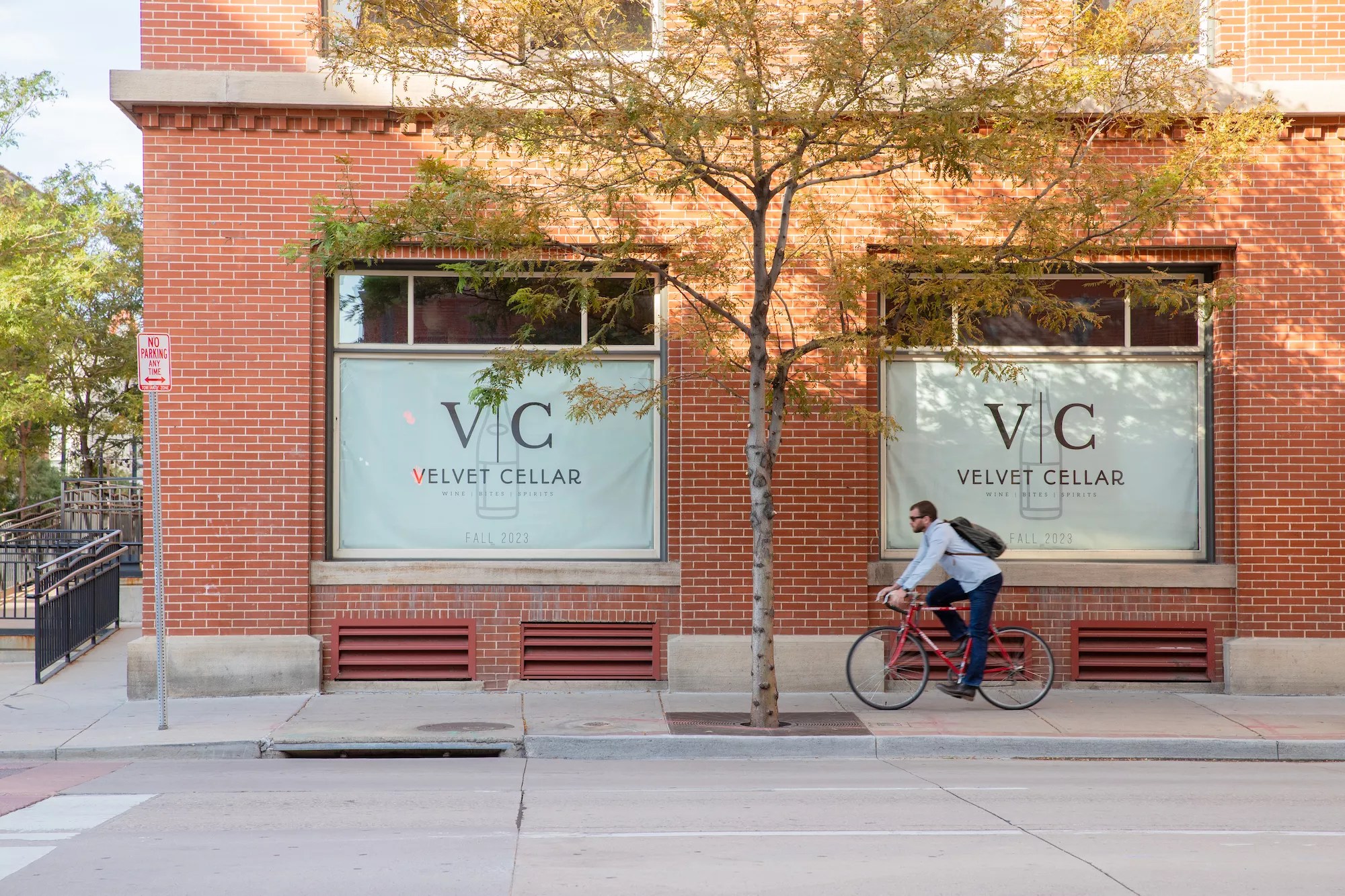 man riding bike in front of a brick building