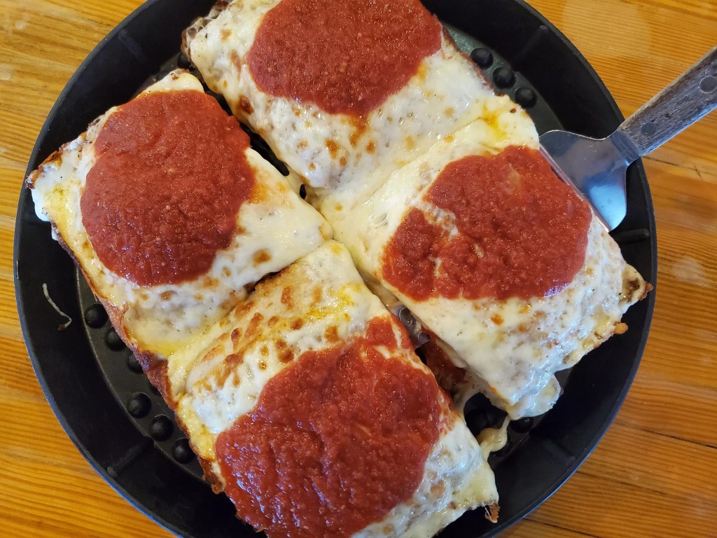 square slices of cheese pizza with sauce on top