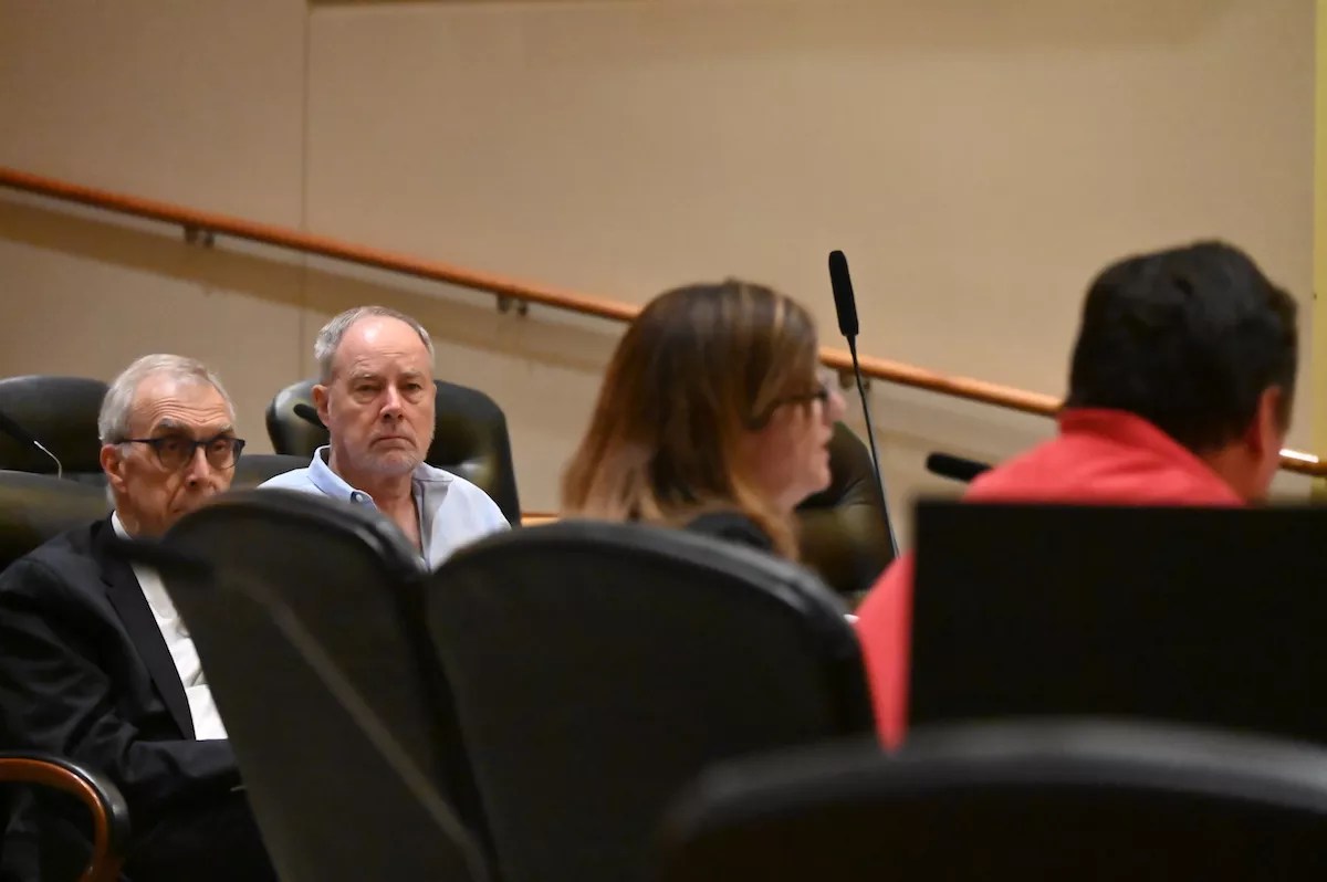Charlie Richardson and his lawyer Mark Grueskin listen to attorney Suzanne Taheri during a protest hearing with the Aurora City Clerk.