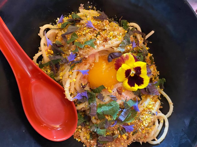 a spaghetti dish with an egg yolk