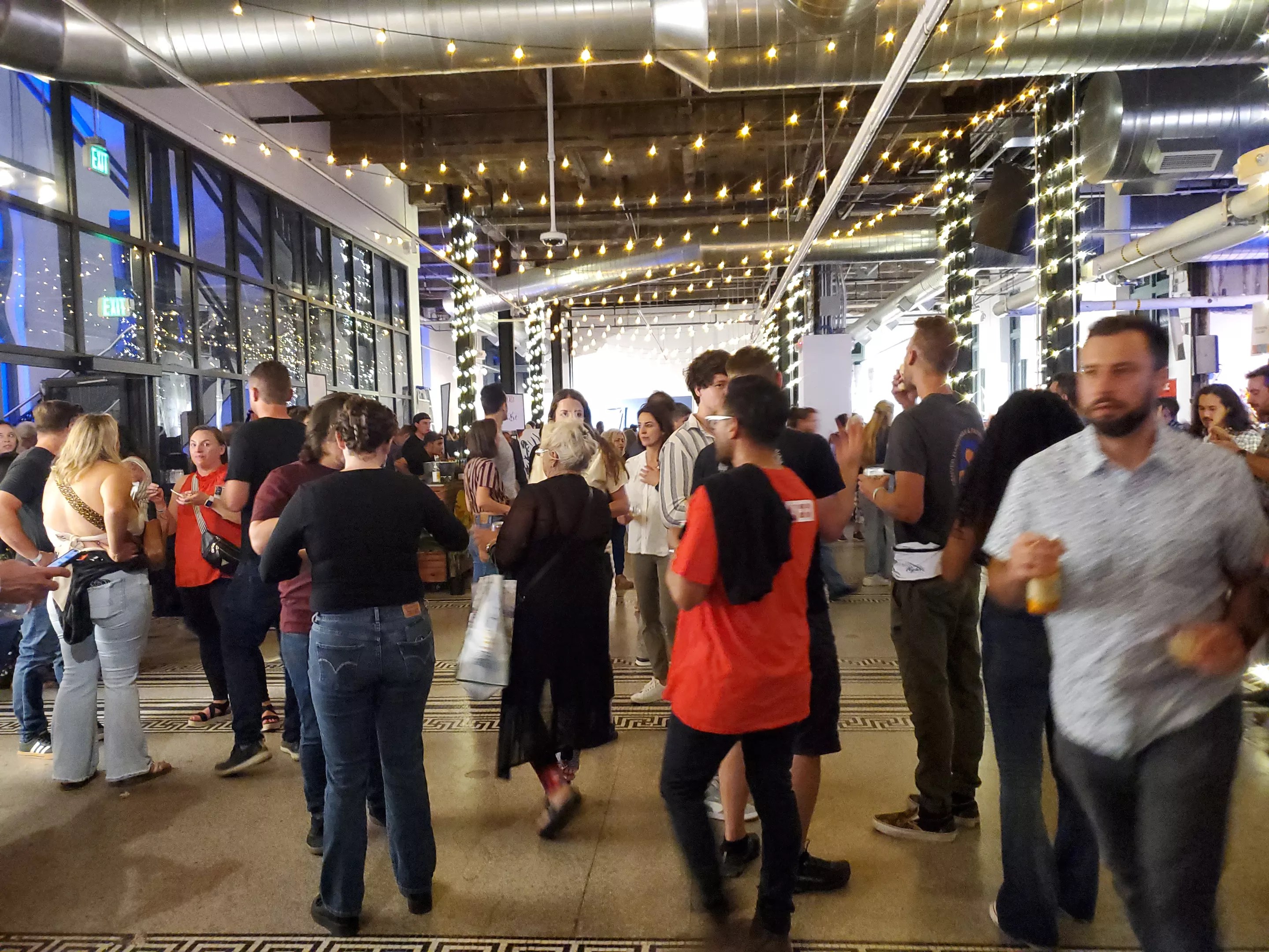 people standing under string lights