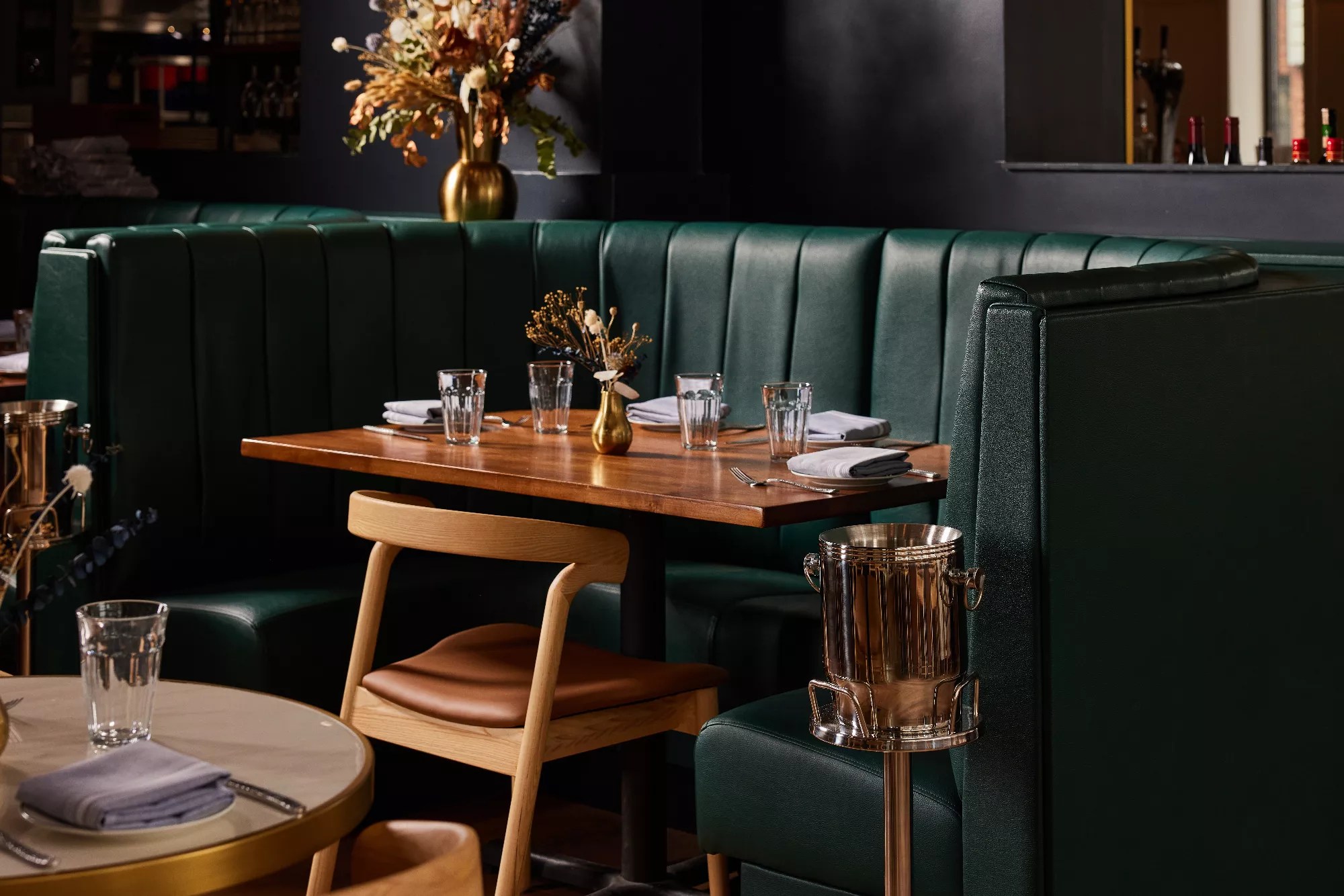 a wooden table in front of a green booth