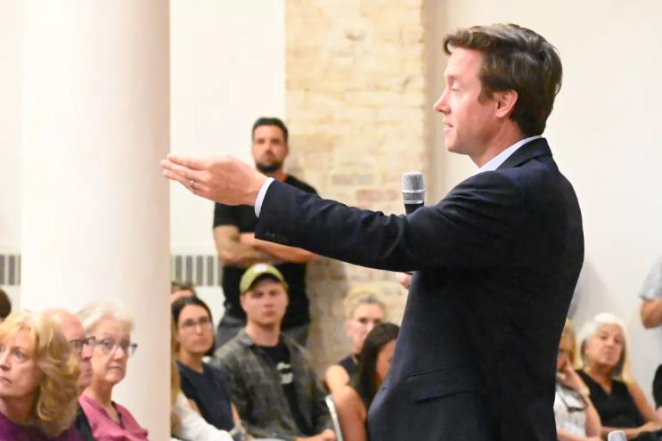 Mike Johnston speaks during a town hall in the Golden Triangle.