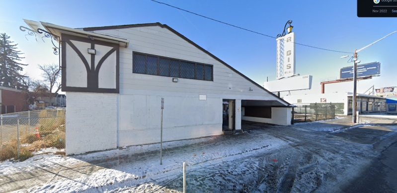 A white building sits in front of a dilapidated sign that says "RGIS".