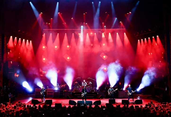 band on stage with red lights in the background