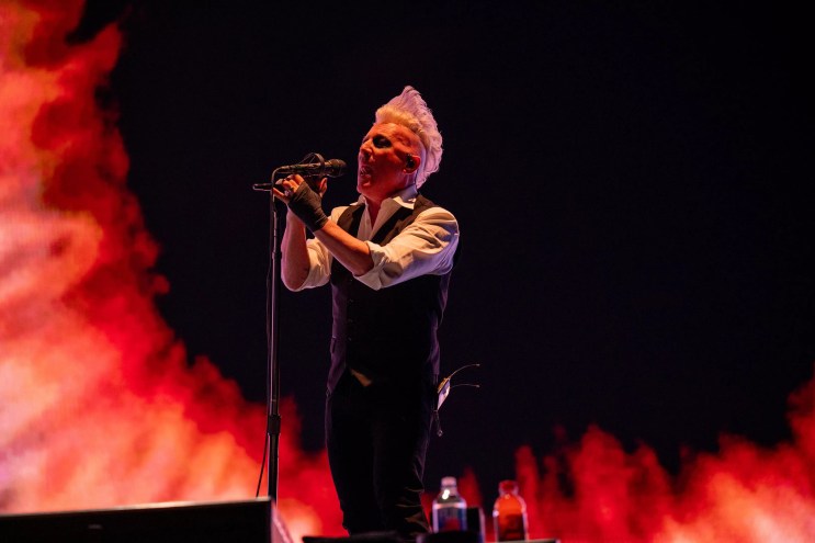 blonde man sings into microphone