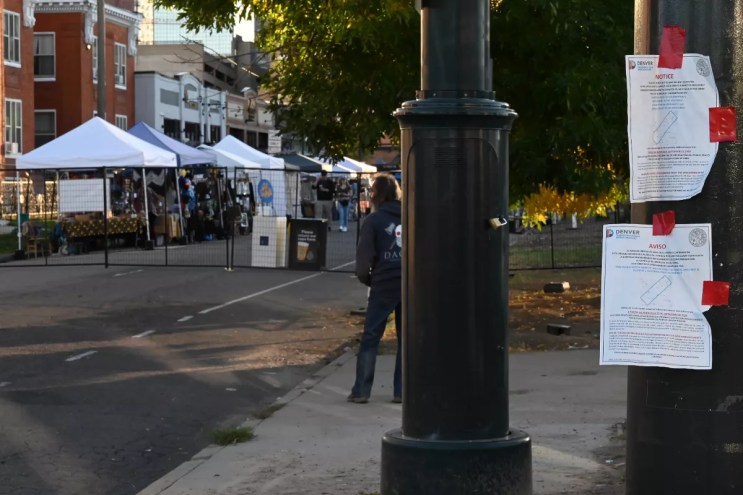 A homeless man stands in area that's a permanently posted cleanup area.