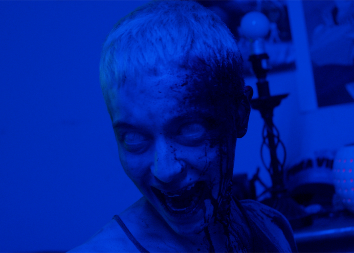 blue lighting covers woman with short hair and fangs