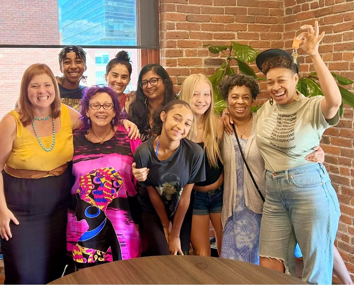 A group of women smiling at the camera with arms around each other.