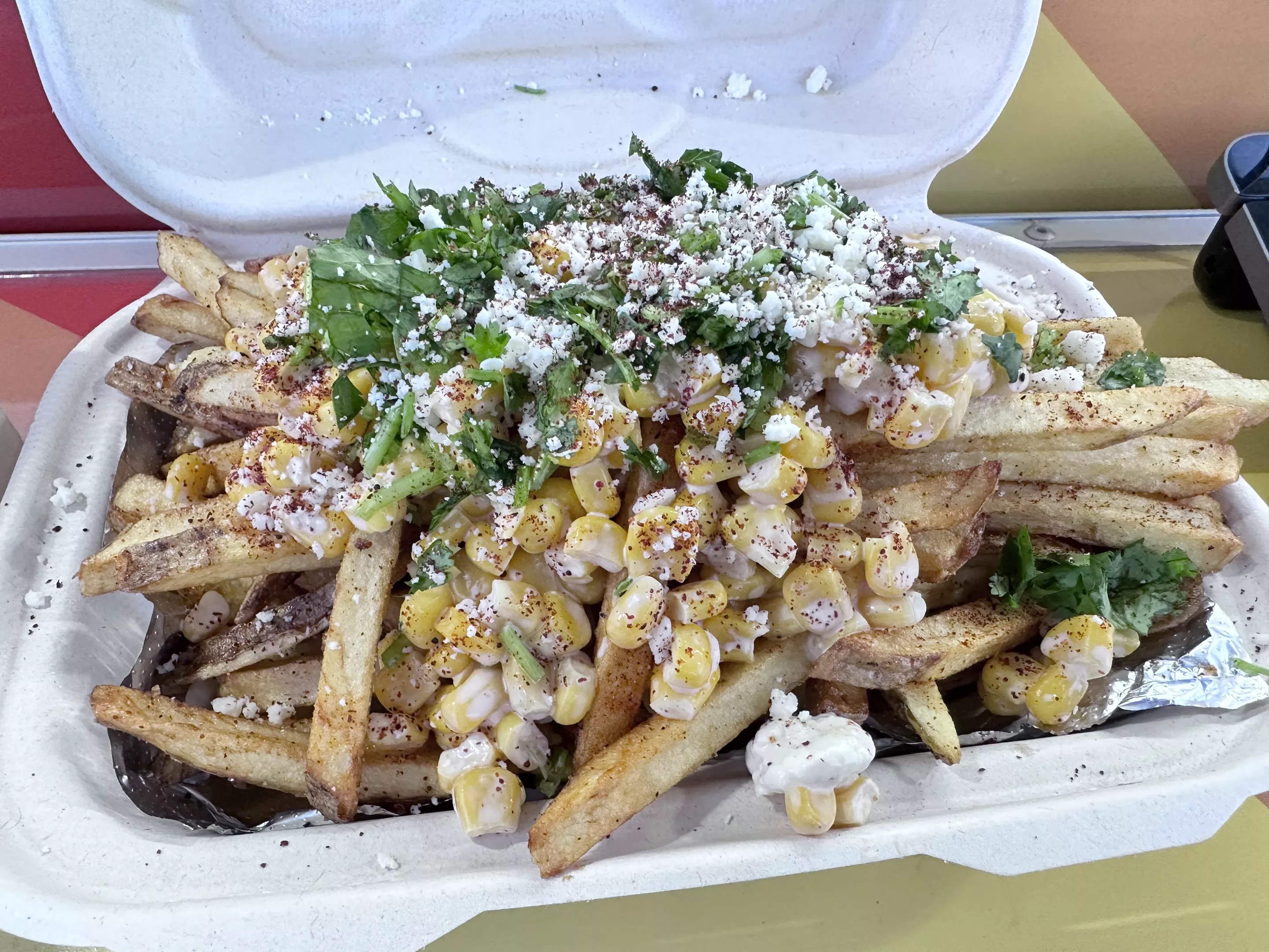 fries topped with corn, crema and cilantro