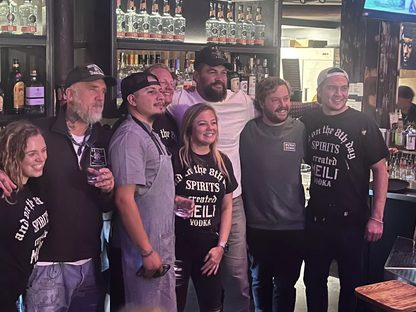 a group of people posting for a photo in a bar