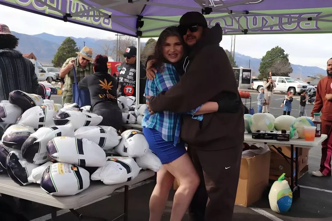 A man and woman hug at a food drive