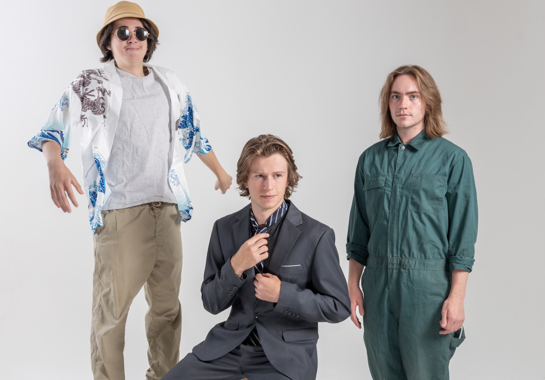 three musicians stand in a white room