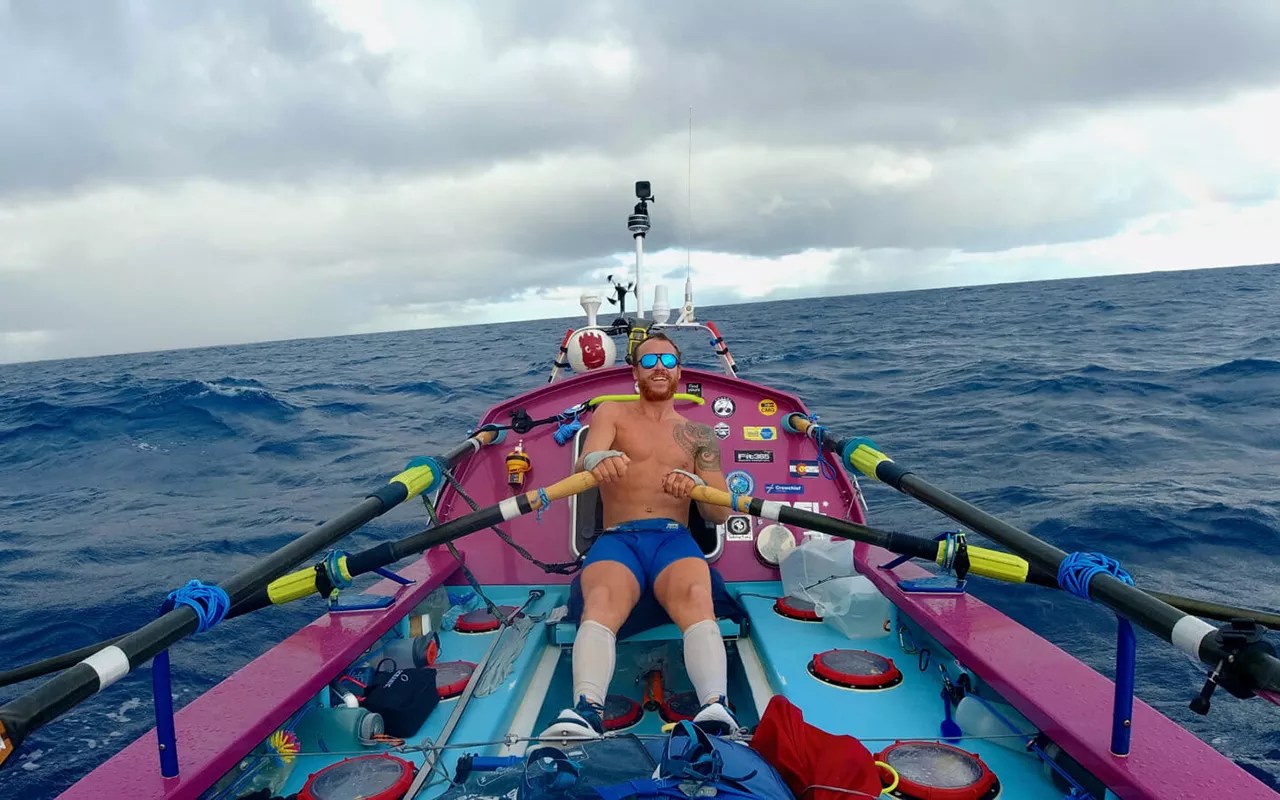 man in boat rowing on ocean