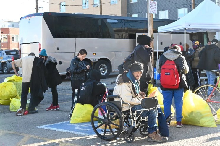 Homeless residents prepare to board a bus bound for housing.