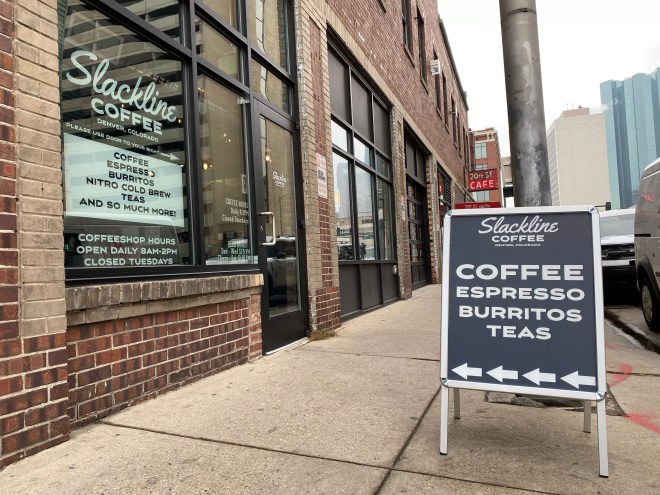 sandwich board sign in front of a brick building