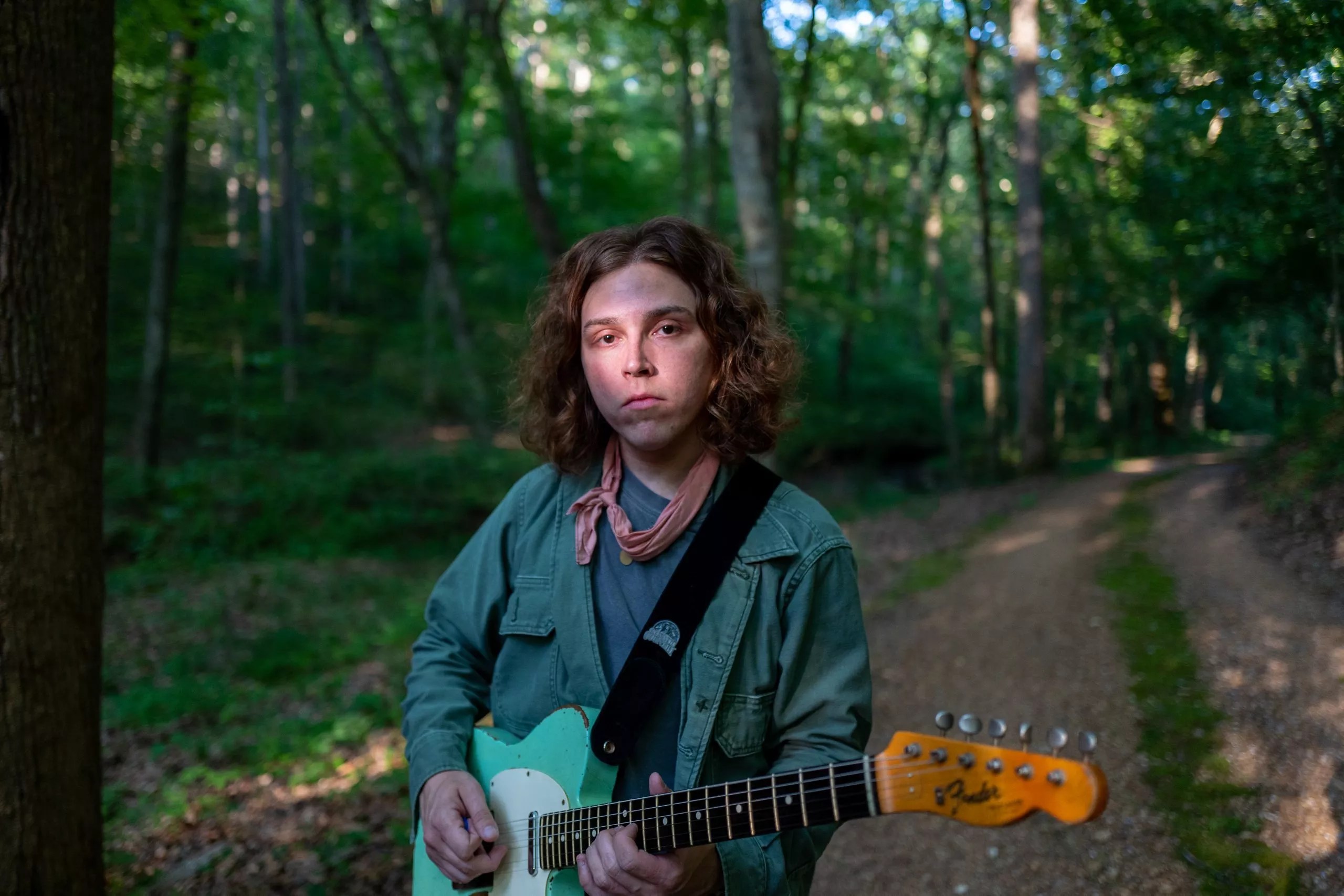 man holding a guitar outside