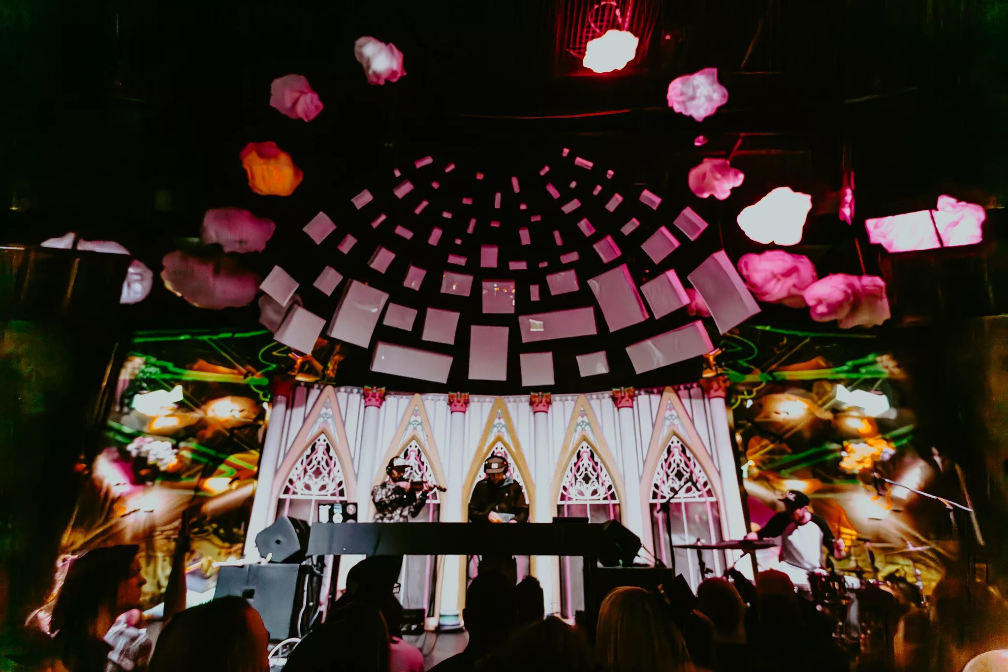 dj and violinist on stage with cathedral-inspired light show effects