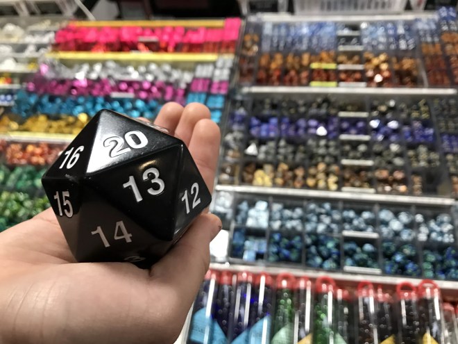person holding a 20-sided dice