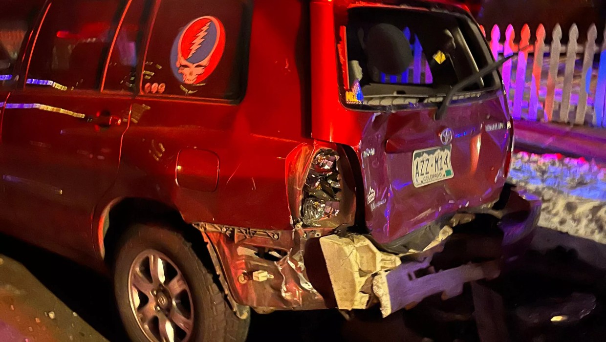 A red Toyota Highlander with the rear bumper destroyed.
