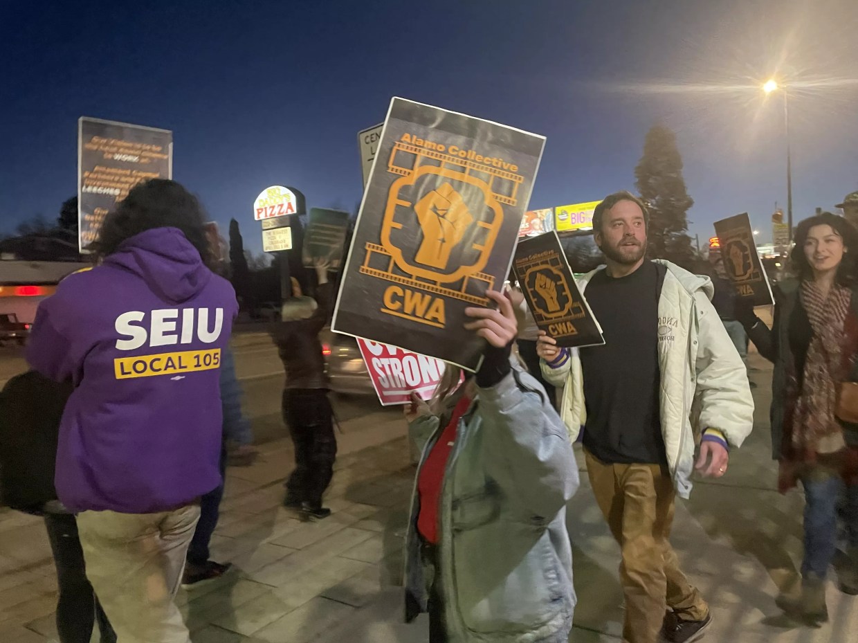 A person holds a poster while picketing.