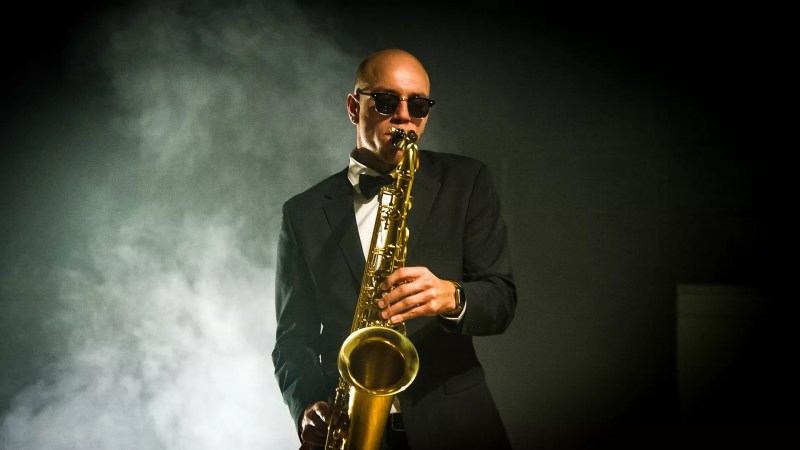 man in suit playing saxophone