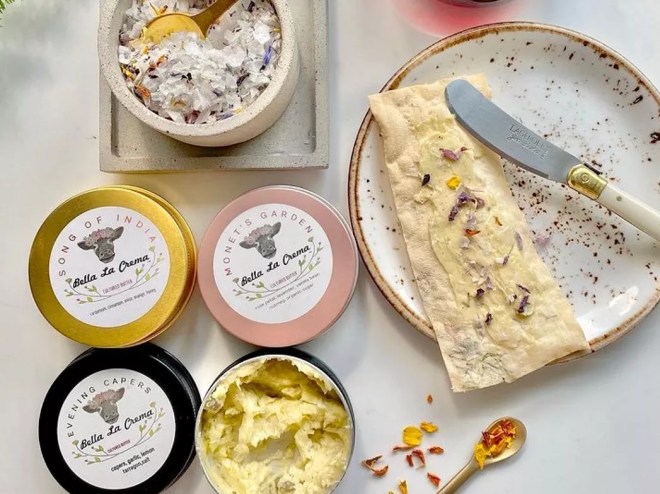 a cracker spread with butter next to butter in packaging