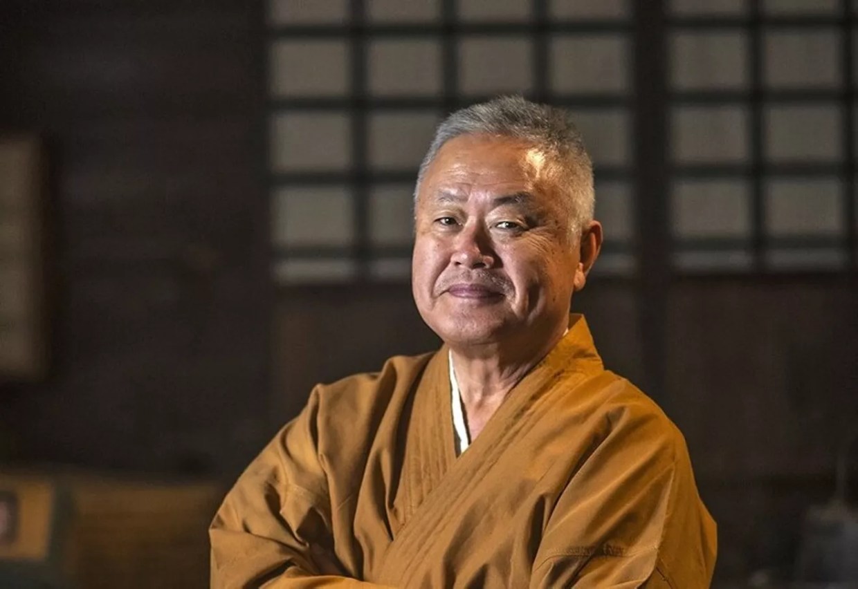 Man in Japanese outfit at restaurant.