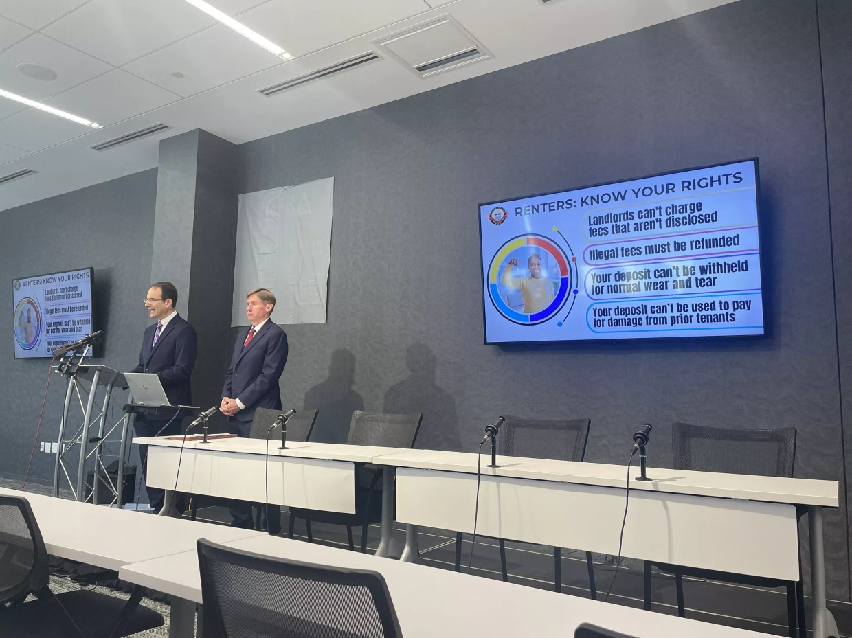 Two men in navy suits stand at a podium.