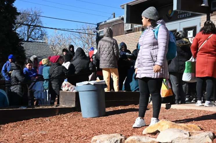 A Venezuelan migrant looks over a line at a food pantry.