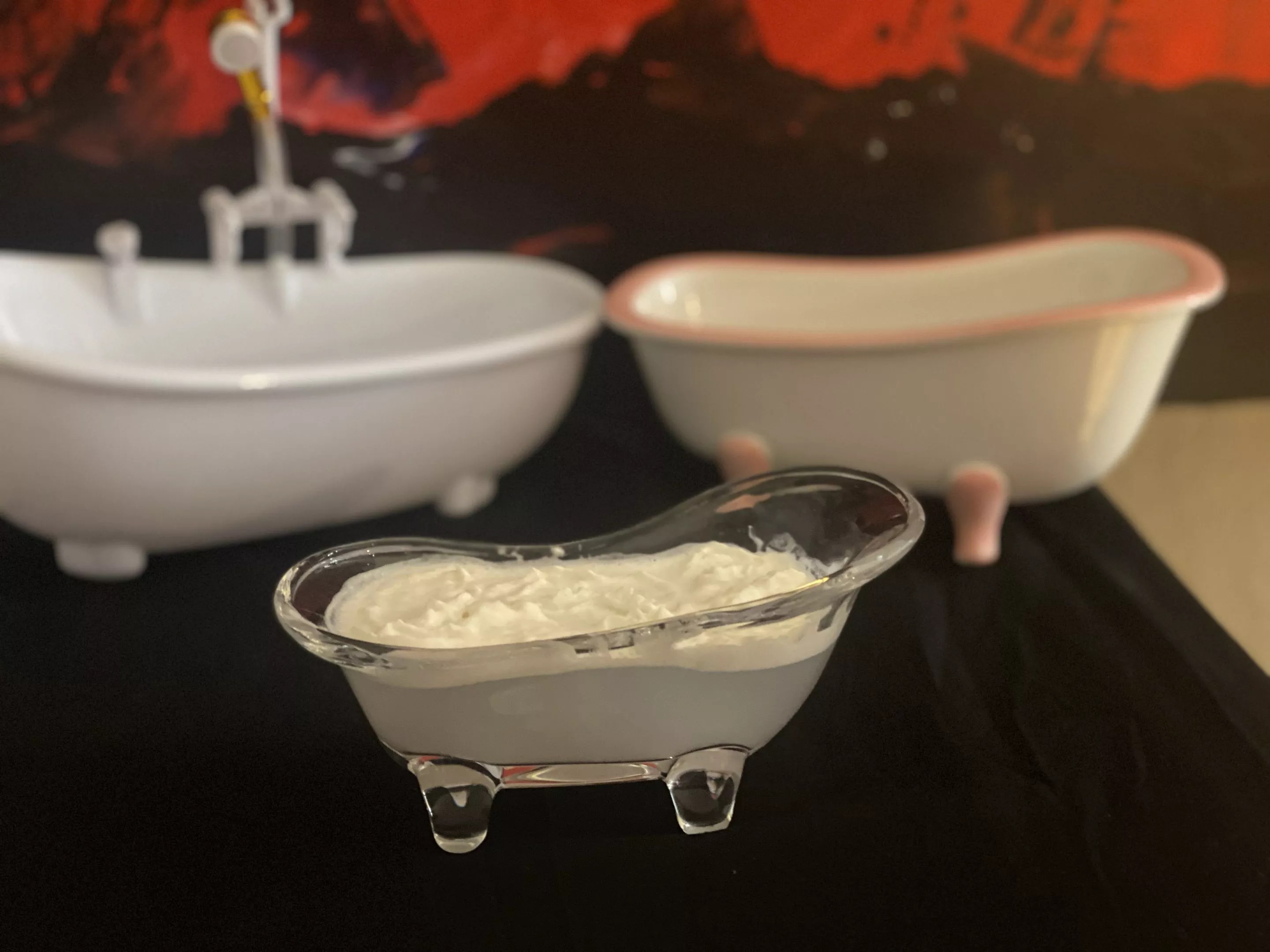 a white cocktail in a bathtub-shaped glass
