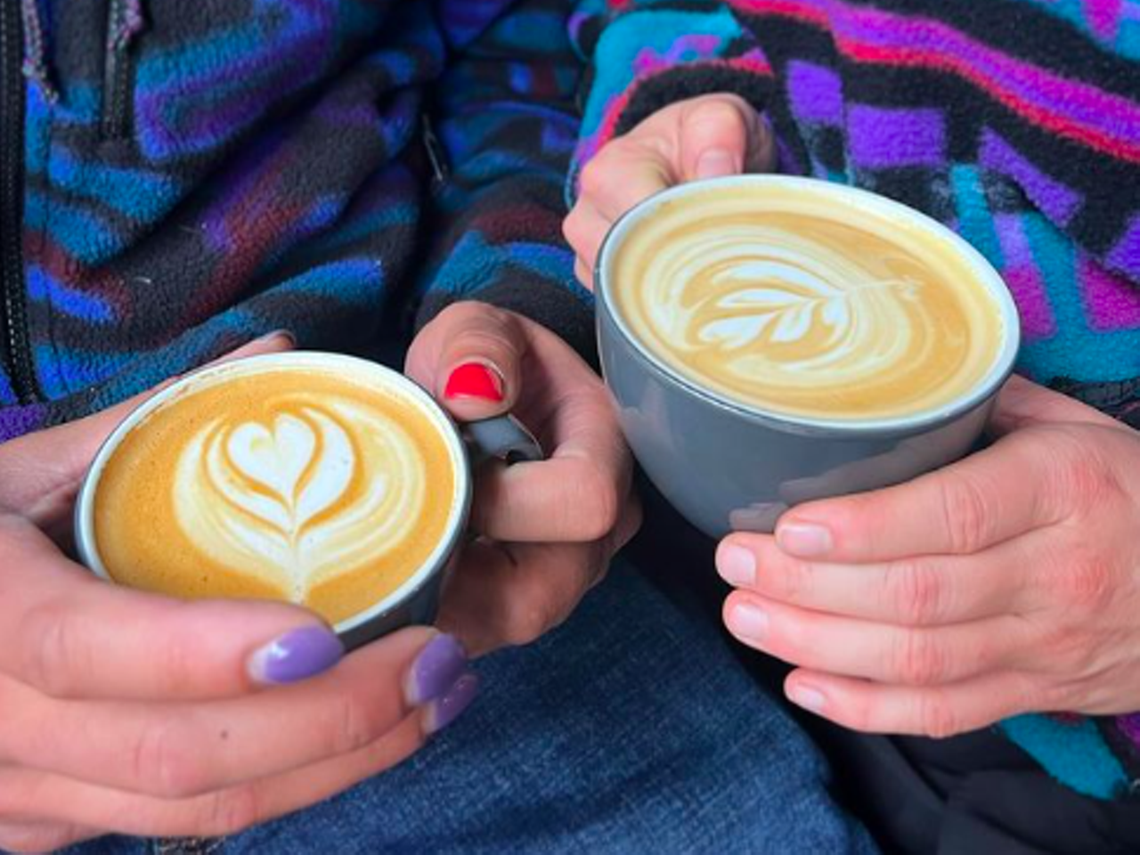 hands holding two lattes