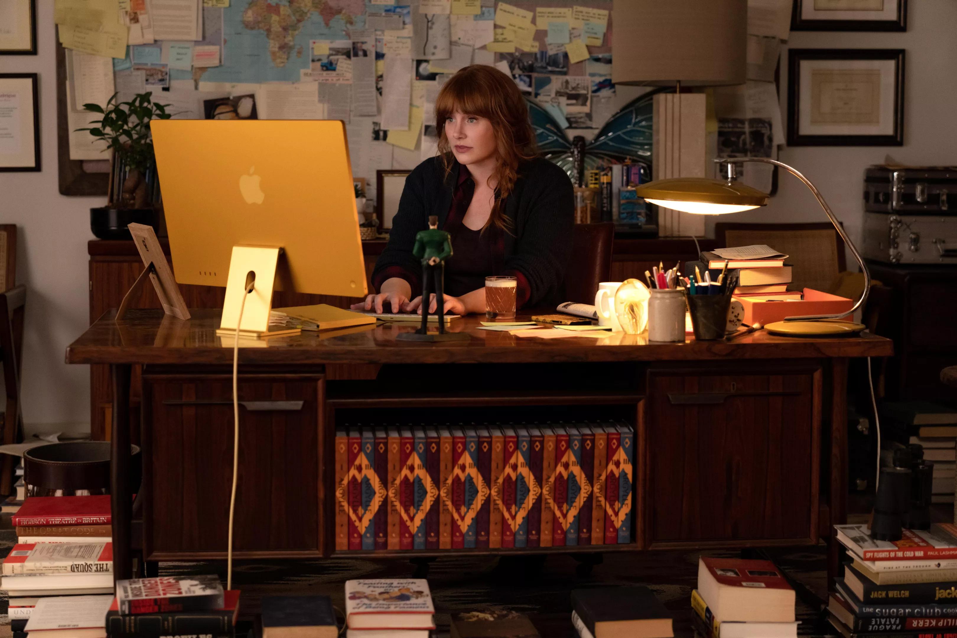 woman with red hair typing at a desk