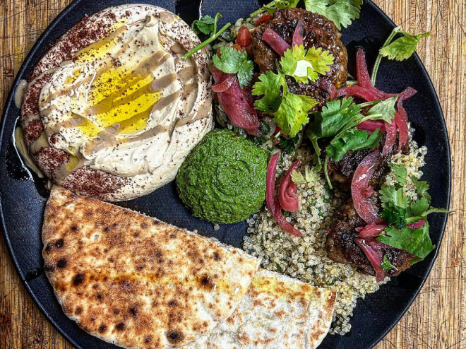 a plate with pita, hummus and lamb