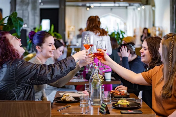 A group of women toasting wine glasses