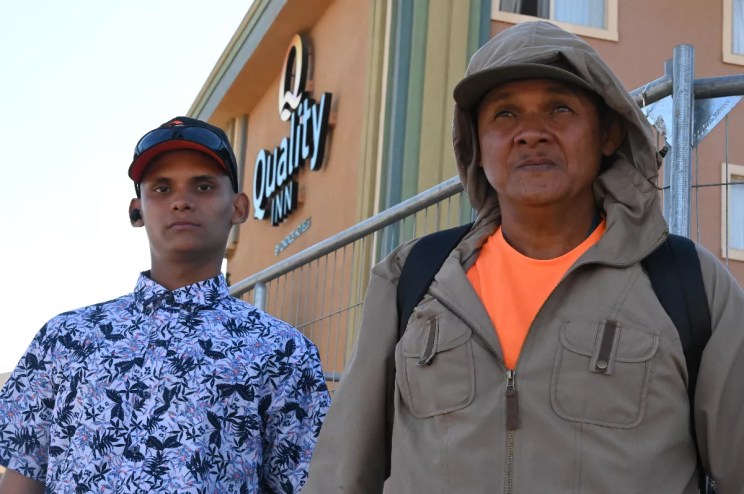 A father and son who are Venezuelan migrants stand outside a shelter.