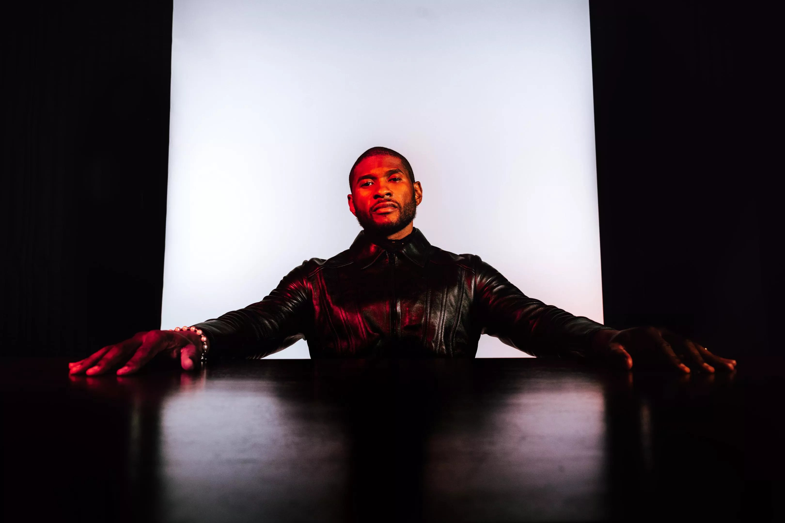 usher sits at a table