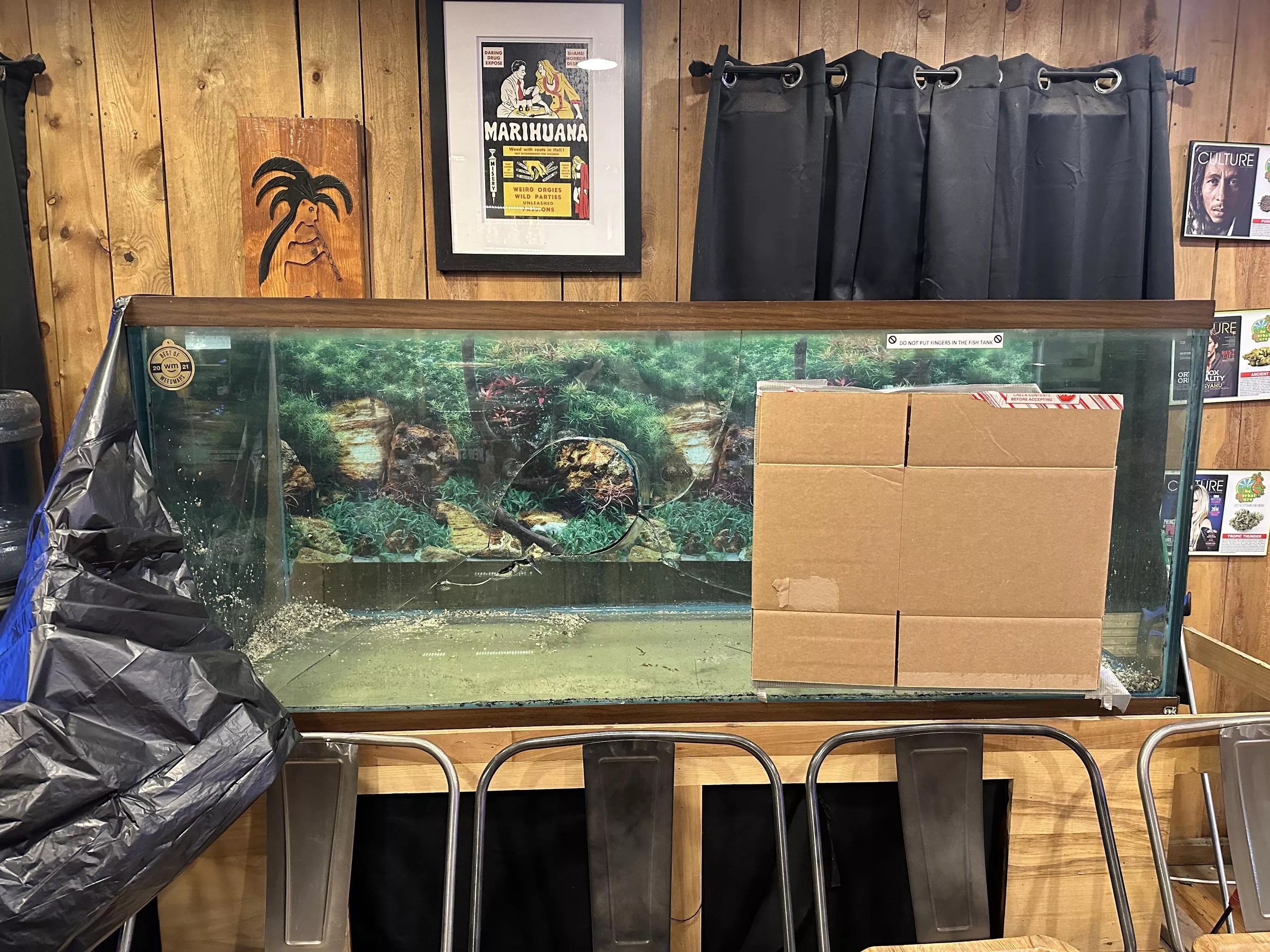 Broken glass fish tank with a hole in it.