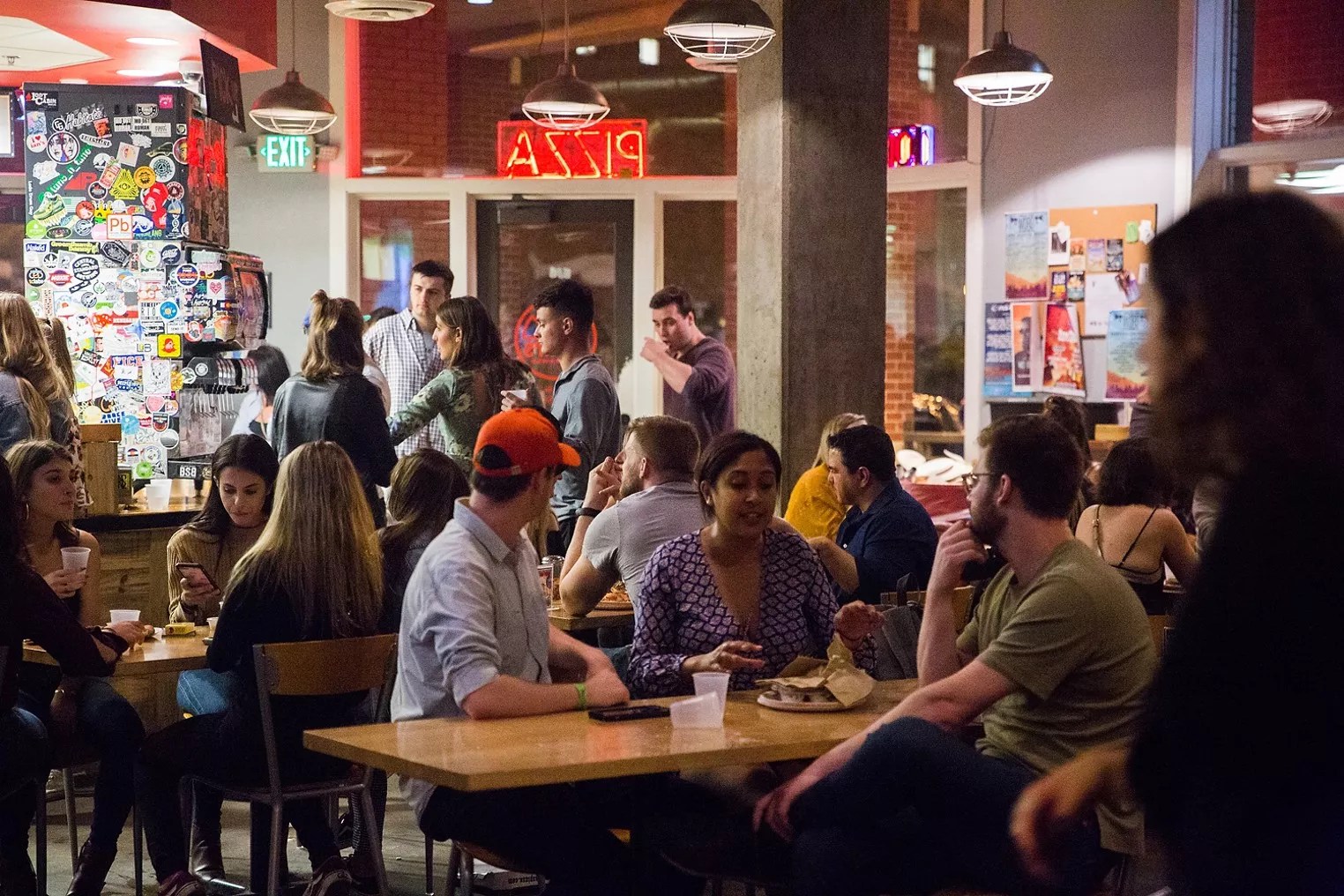 people sitting at tables inside a restaurant