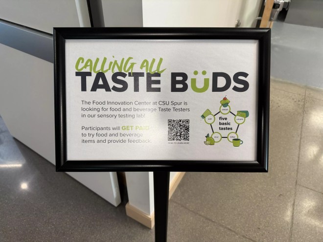 a sign in a stand that says "calling all taste buds"