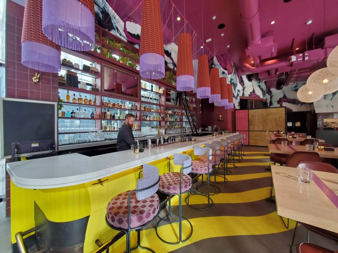 interior of a bar with pink and yellow decor