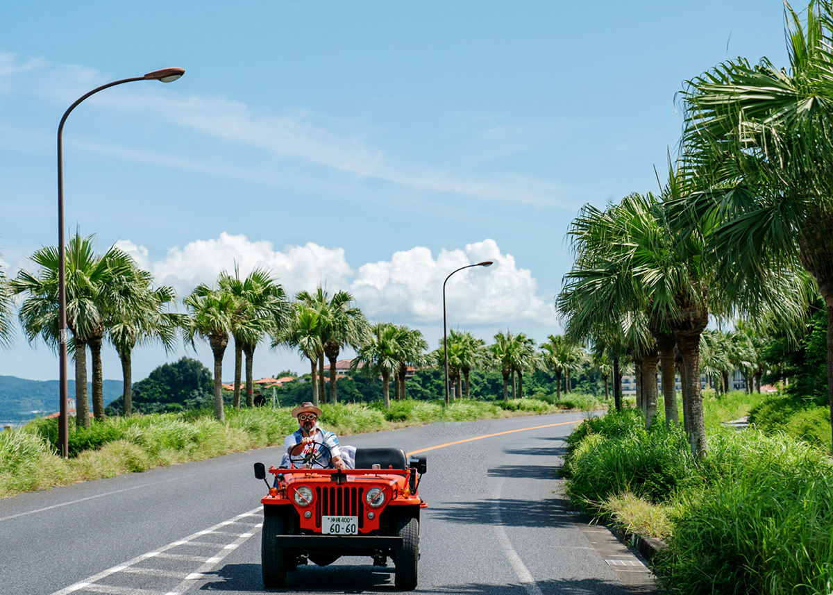 red car driving down a road