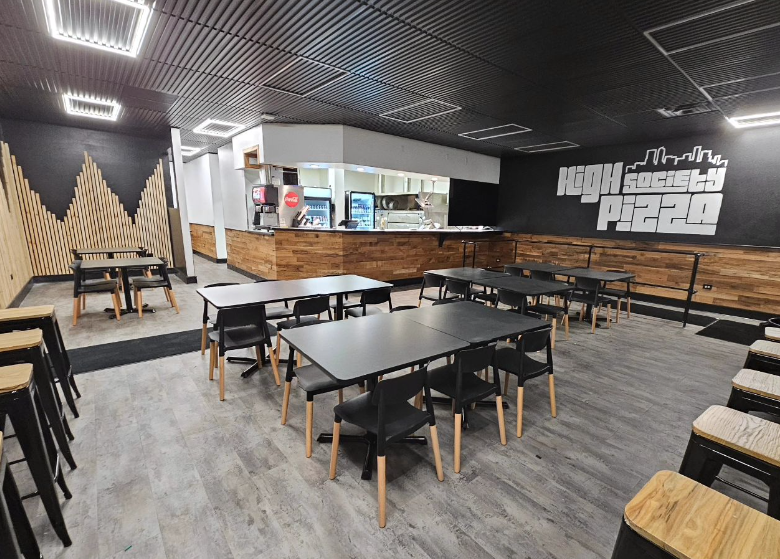 interior of a restaurant with black tables and chairs