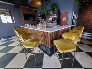 yellow velvet stools surrounding a bar