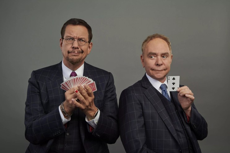 two men in suits holding cards